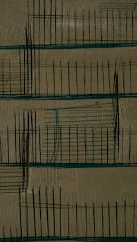 Aerial shot of a construction site with patterned metal fences casting shadows.