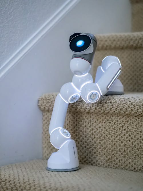 Free White Ai Robot on the Stairs Stock Photo