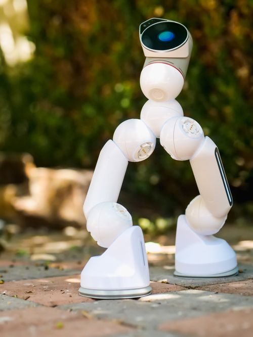 Free White robot on pavement, showcasing innovation and modern robotics technology. Stock Photo