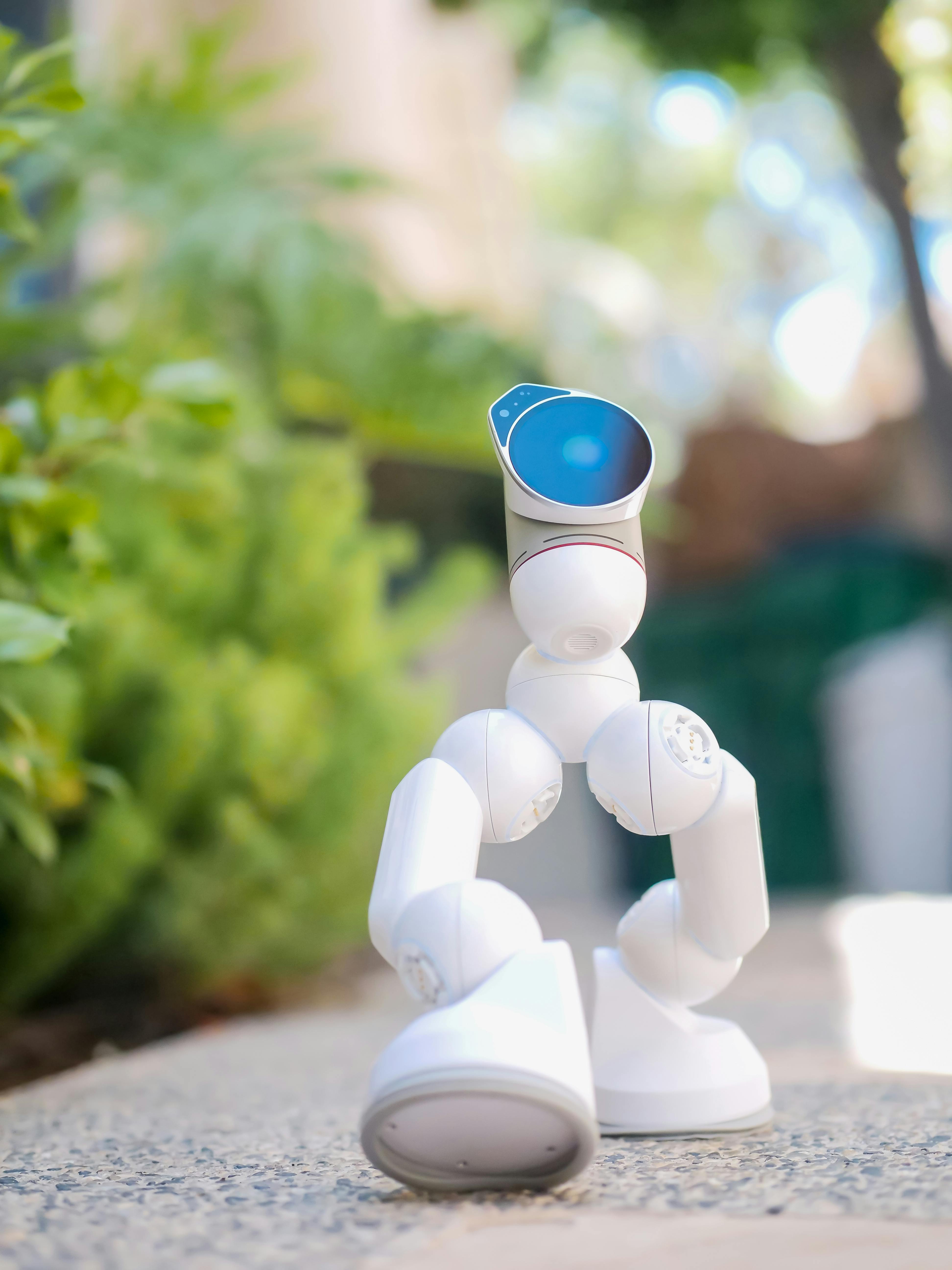 white robot toy on gray concrete floor