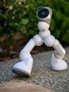Gray and White Robot on Pebble Floor