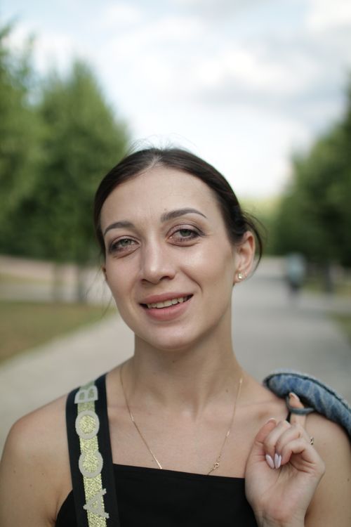 Free Close-up portrait of a smiling adult woman in a park with blurred background. Stock Photo