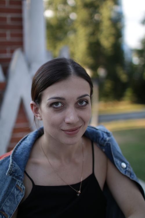 Free Portrait of a woman smiling in outdoors setting with denim jacket. Stock Photo