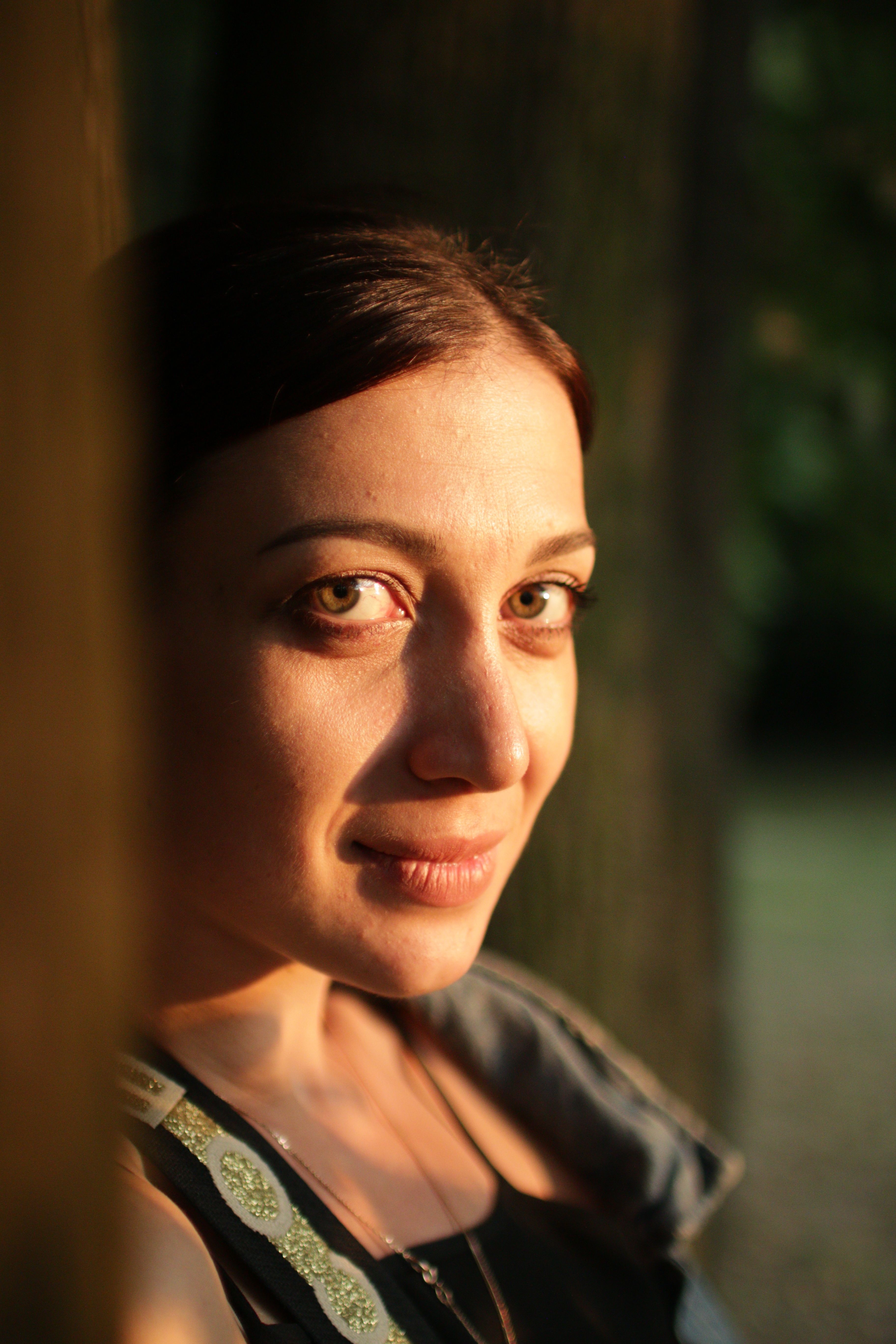 Close-up portrait of a woman in soft natural light during sunset.