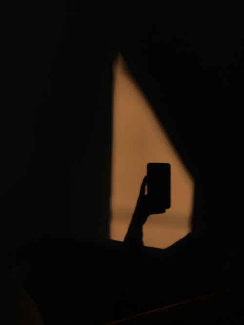 Shadow of a Person Holding a Smartphone