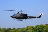 Black Helicopter Flying Above Green Trees