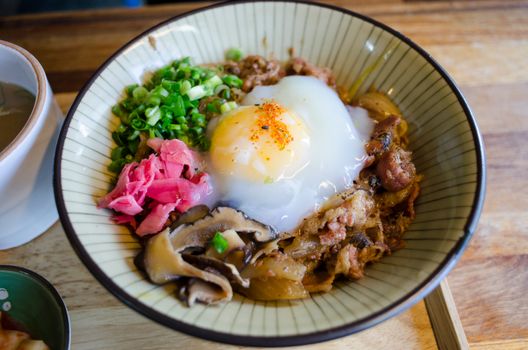Mouthwatering Asian noodle bowl with poached egg, mushrooms, and green onions.