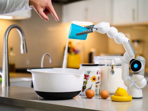 Free Robot Hand Pouring Flour into White Bowl Stock Photo