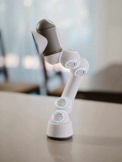Photo by Kindel Media A sleek and modern robotic arm displayed on a table indoors, highlighting innovation.