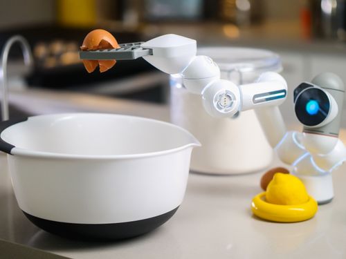 Free A robotic helper cracks an egg into a bowl in a contemporary kitchen setting, showcasing automation in cooking. Stock Photo