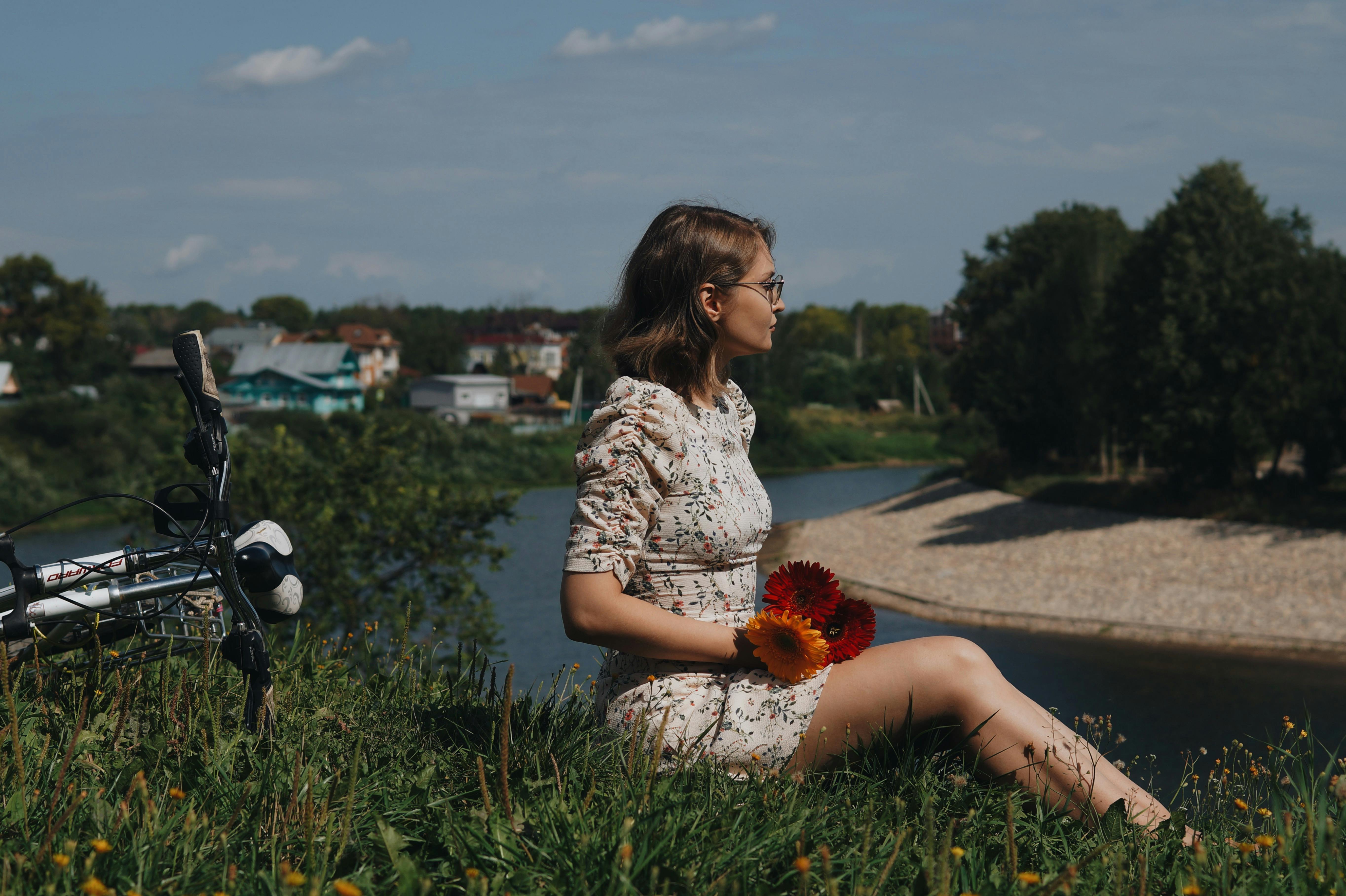 A Woman In Black Floral Long Sleeves Dress Sitting On A Boat While