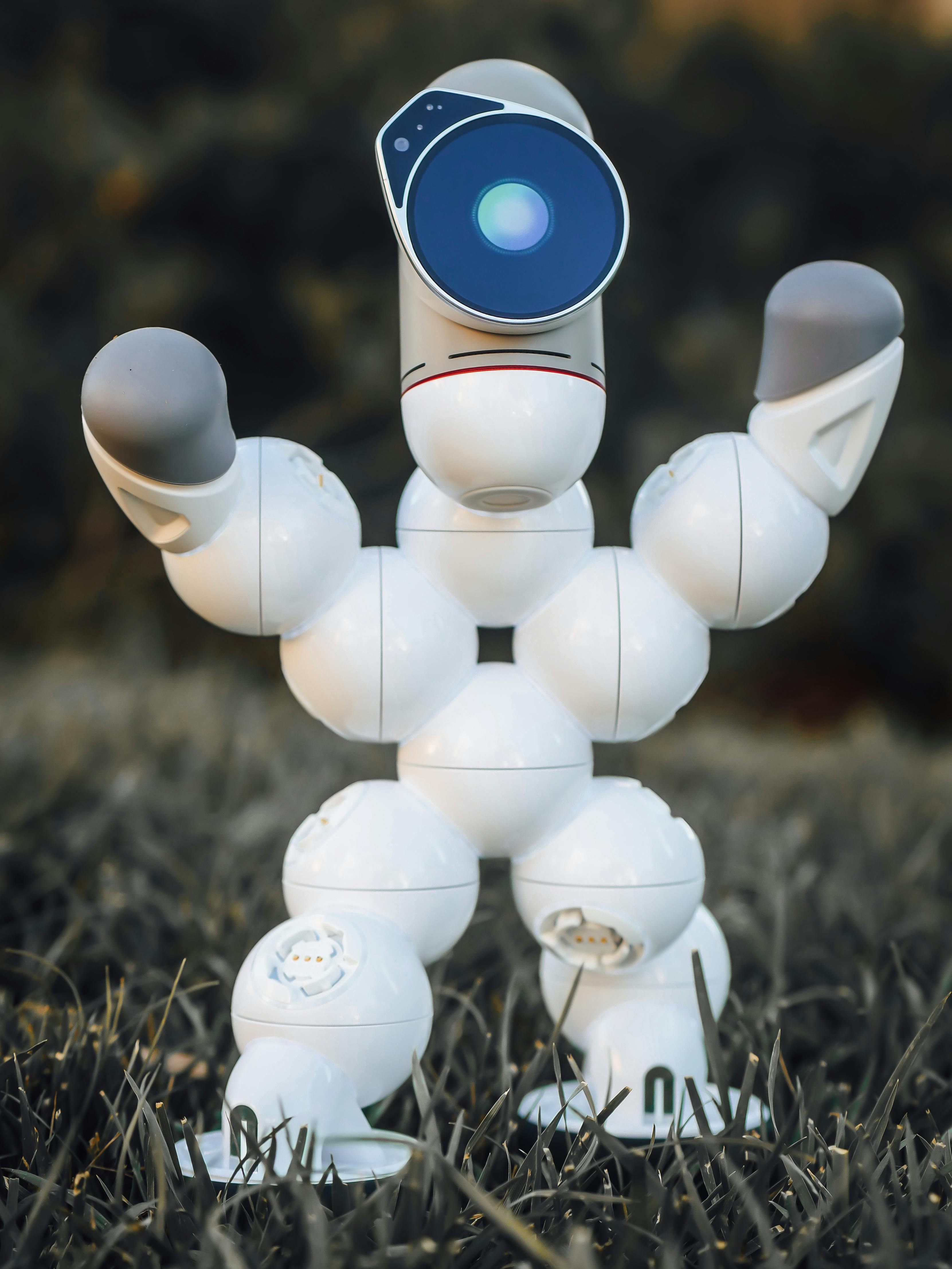 close up shot of a robot standing on a grassy ground