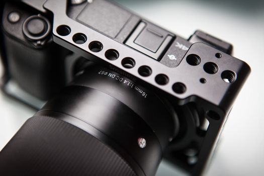 Detailed view of a camera with a lens mounted in a sturdy metal cage. Perfect for filmmakers.