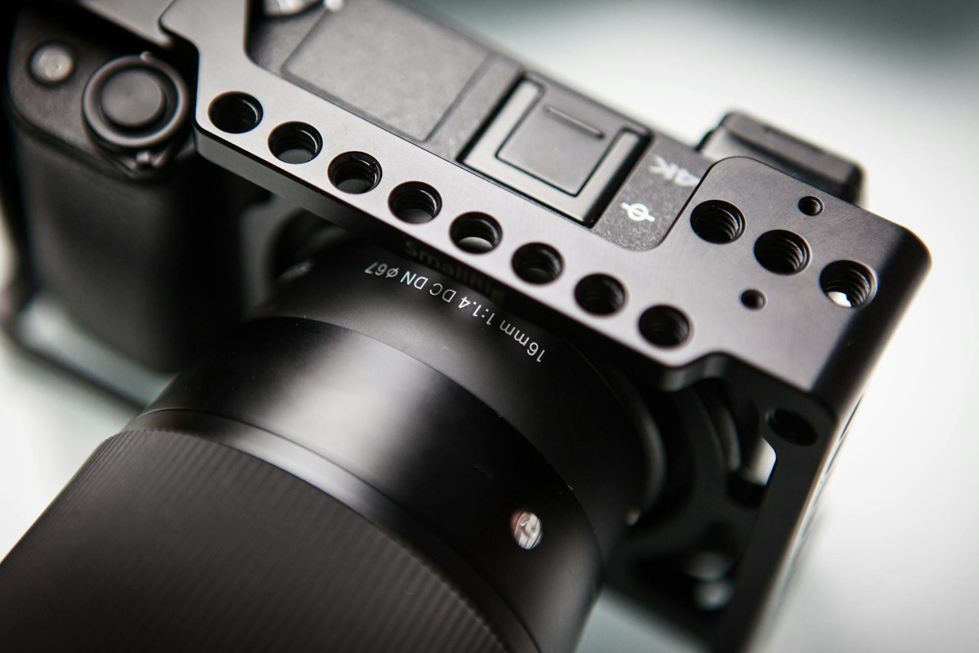 Detailed view of a camera with a lens mounted in a sturdy metal cage. Perfect for filmmakers.