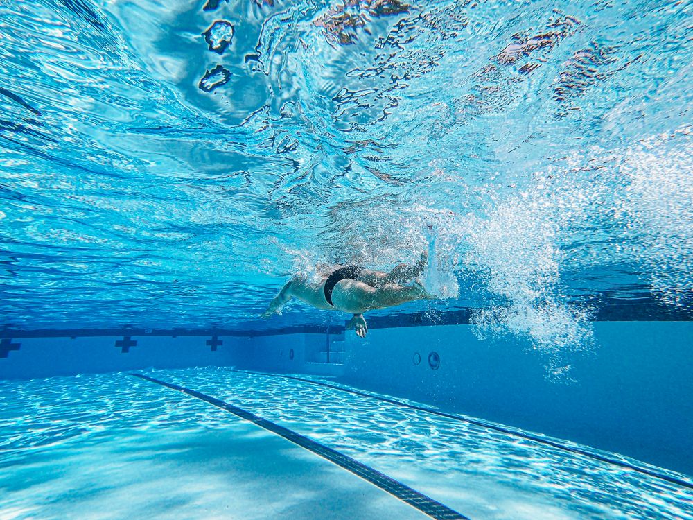 Schwimmer stößt sich unter Wasser von der Wand ab