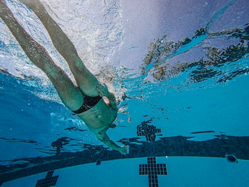 A Man in Black Trunks Swimming in the Pool