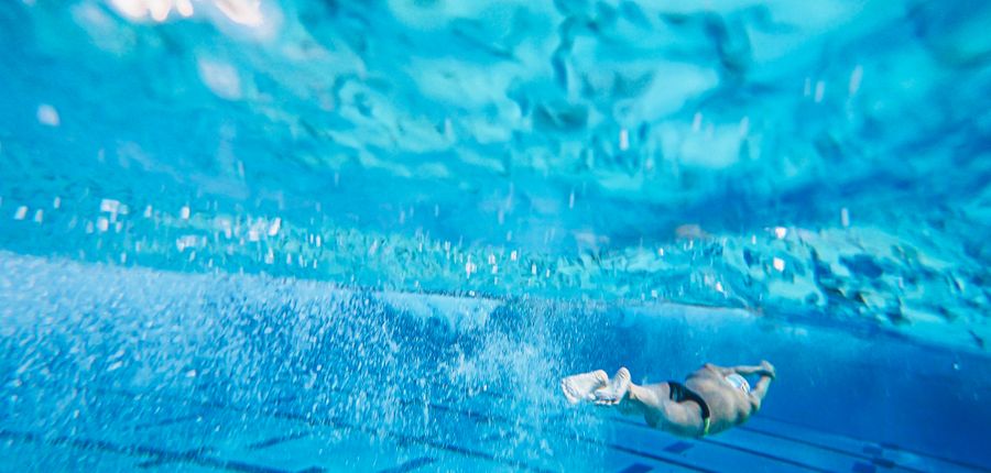 Swimmer underwater beside pool lane dividers — Kindel Media on Pexels