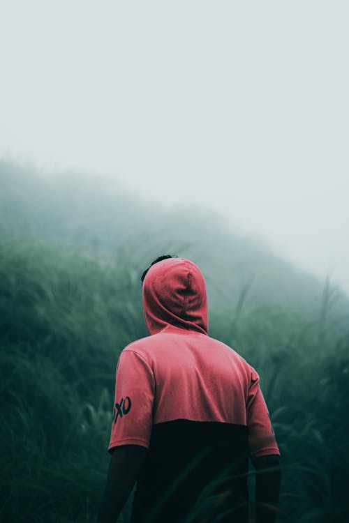 Free Person in Hoodie Shirt Standing on Mountainside Stock Photo