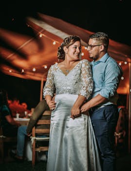 A couple shares a loving moment during an outdoor evening wedding celebration.
