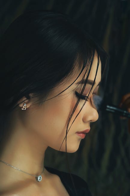 Side profile portrait of a woman with makeup application.