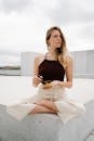 A Woman in Yoga Position Holding a Singing Bowl while Looking Afar