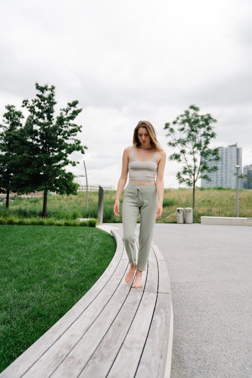 Woman in Gray Tank Top and Gray Pants Walking Barefooted