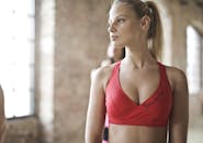 健身房里，一个穿着红色运动胸罩的年轻女子正准备锻炼