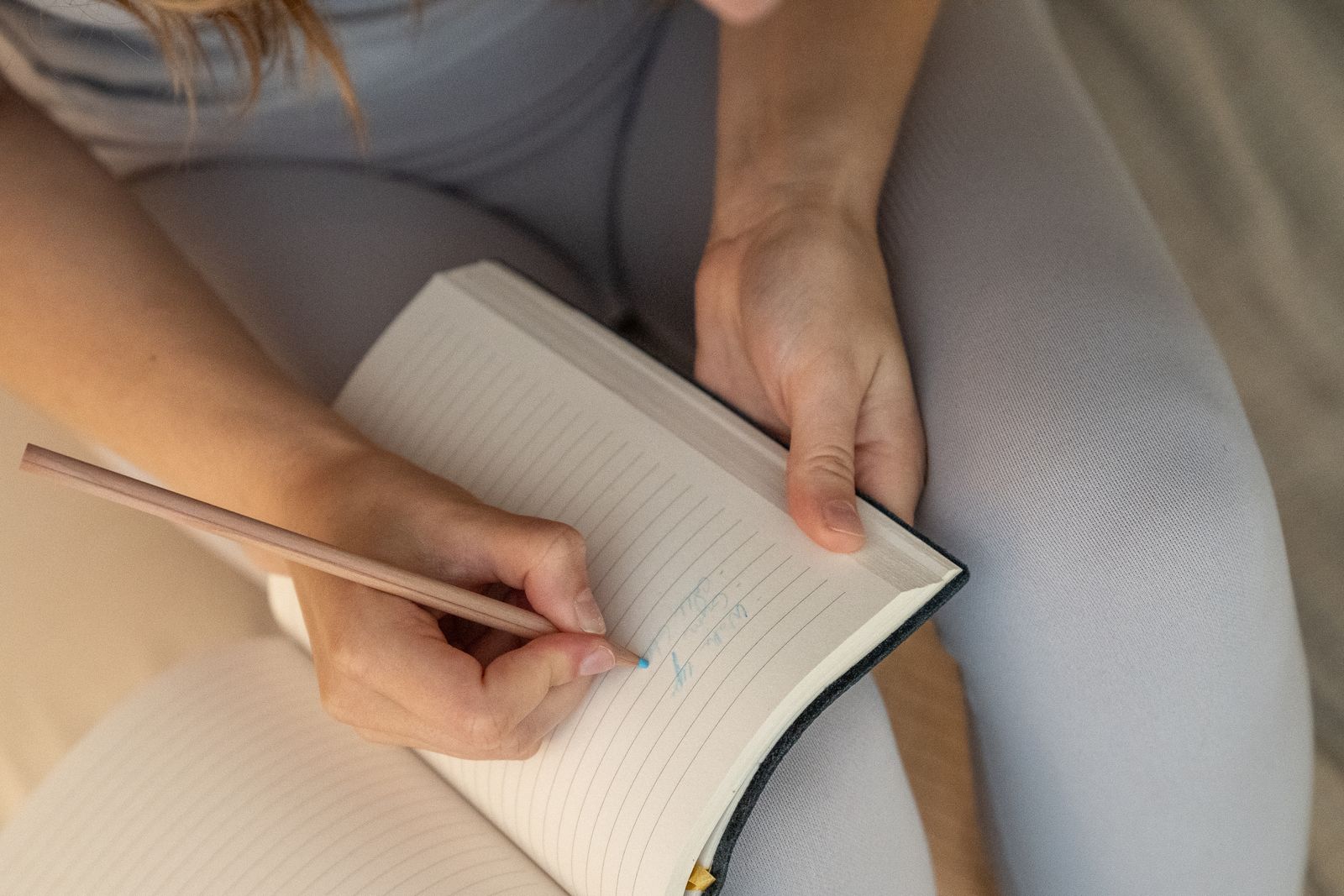 Close-up of hands journaling in a notebook, a common svadhyaya self-study practice