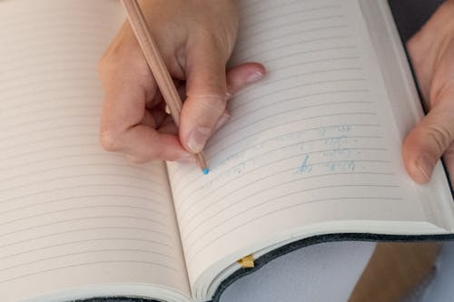 Free Close-up of Writing on a Notebook with Blue Pencil Stock Photo
