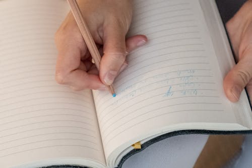 Close-up of Writing on a Notebook with Blue Pencil