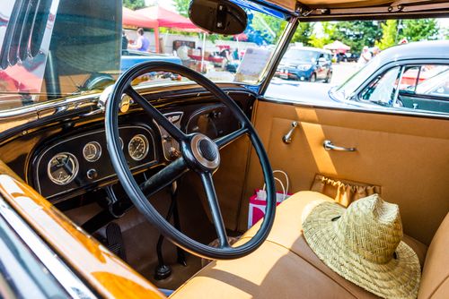 Free Explore a classic vintage car's interior featuring a straw hat and retro dashboard details. Stock Photo