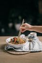 Person Holding Chopsticks and Bowl With Food