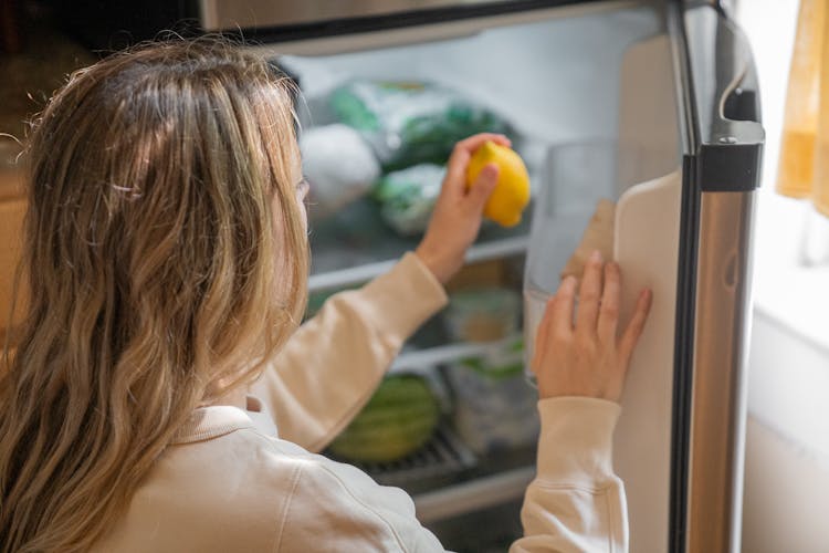 A Woman Taking A Lemon Out From A Fridge