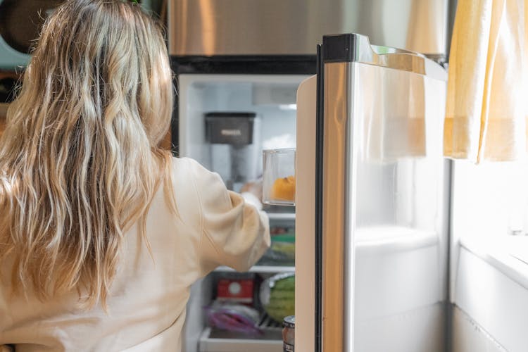 Woman Getting Some Foods In The Refrigerator