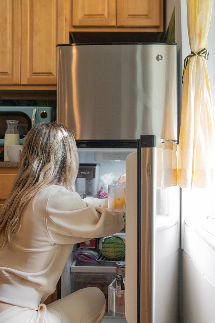 Woman Getting Some Foods In The Refrigerator