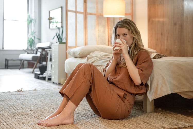 Woman Wearing Her Brown Attire Drinking From The White Mug