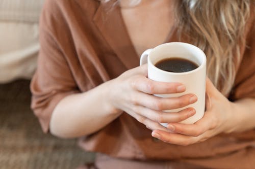Close-Up Shot of a Person Holding a Cup of Coffee