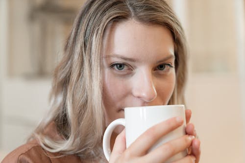 Close-Up Shot of a Woman Drinking a Cup of Coffee
