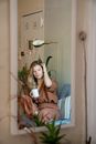 Mirror Reflection of a Woman Holding a Cup of Coffee