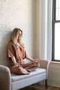 Woman in Brown Clothes Meditating on a Sofa