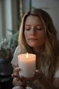 Woman Holding White Pillar Candle