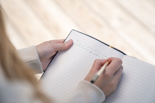 Free Person Writing on White Paper Stock Photo