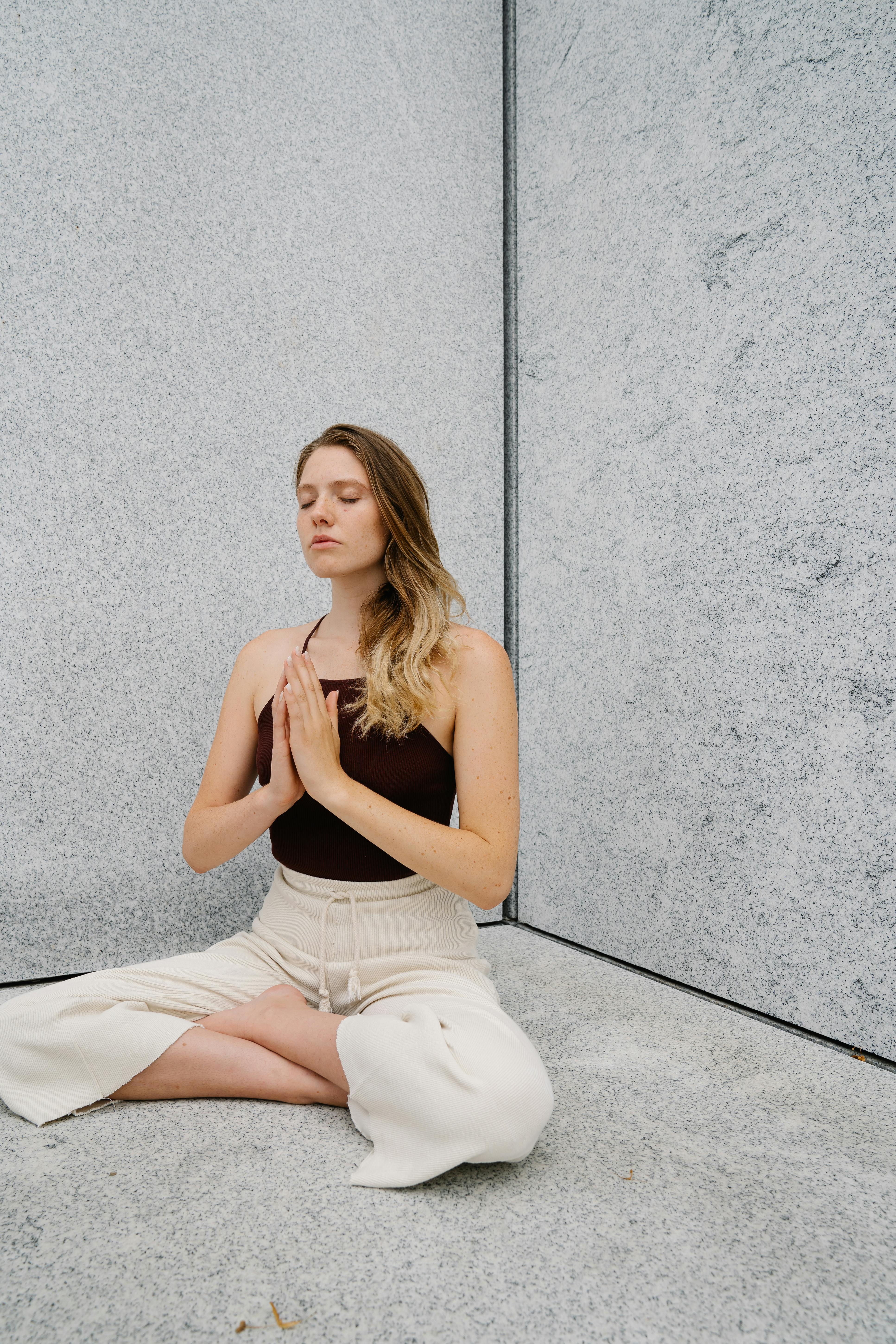 a woman meditating with her hands together