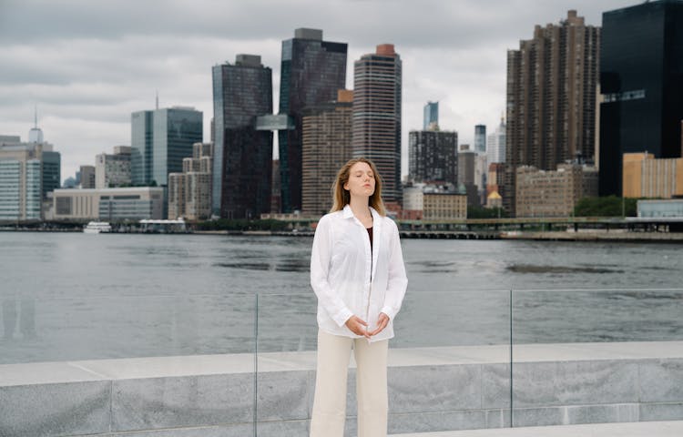 A Woman Meditating Outside With The View Of The City