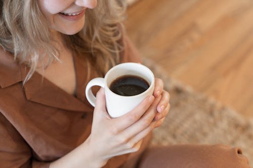 High-Angle Shot of a Woman Holding a Cup of Coffee