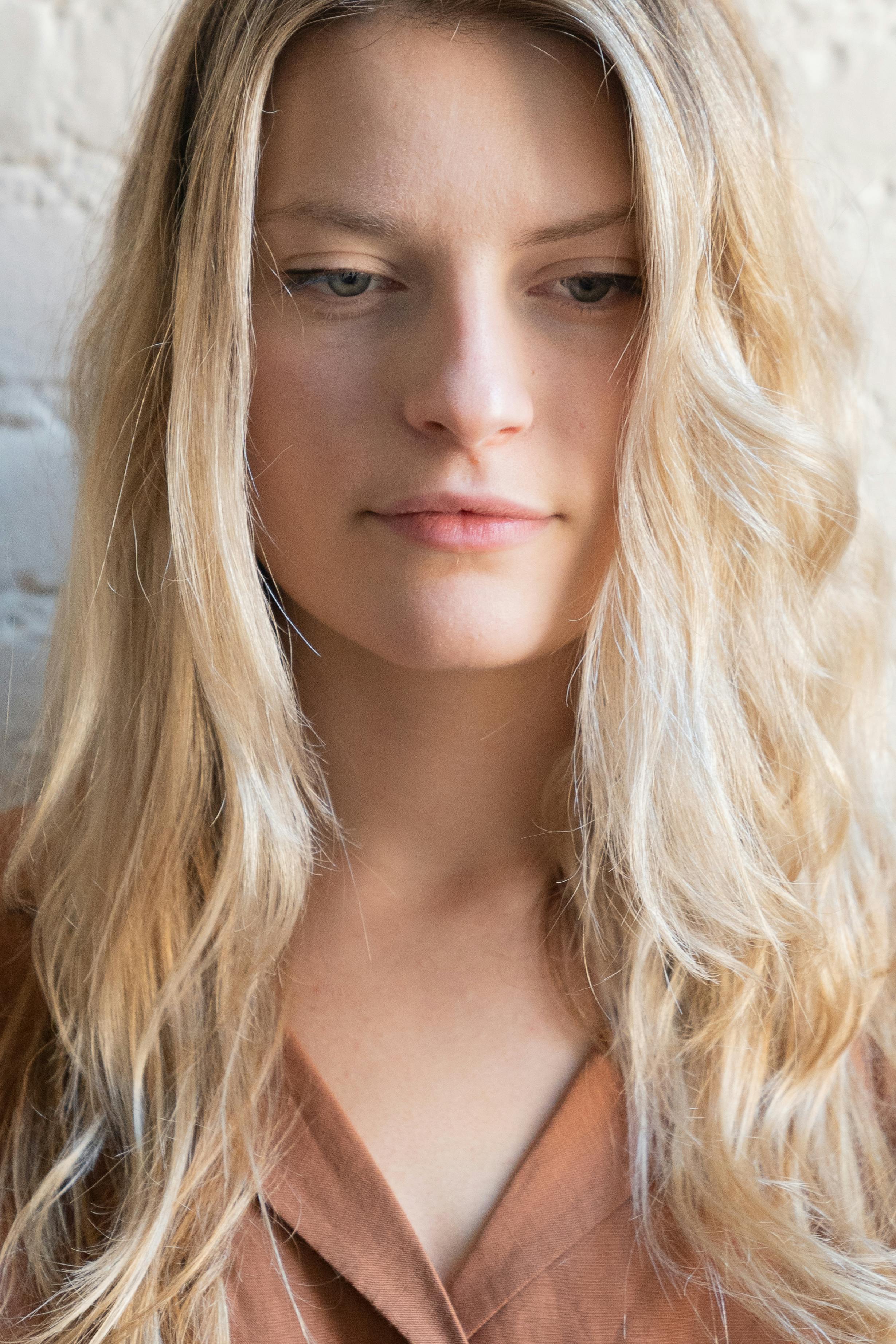 Beautiful close-up portrait of a blonde caucasian woman with a serene expression.