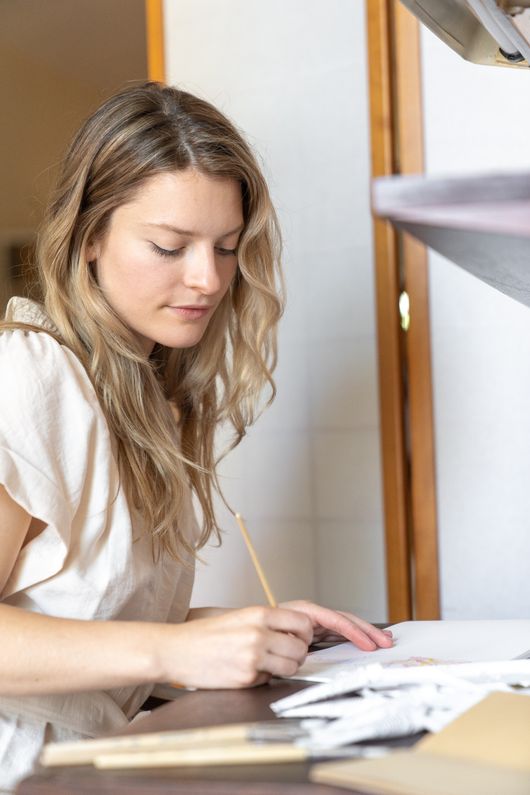 Learner taking notes beside a laptop