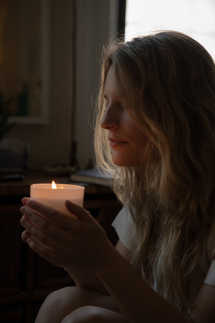 A Woman Holding A Lit Candle 