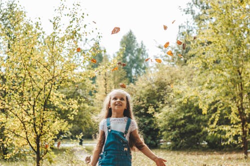 Girl Playing with Dry Leaves