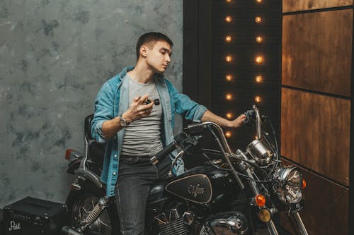 A Man in Blue Denim Jacket Riding a Motorcycle